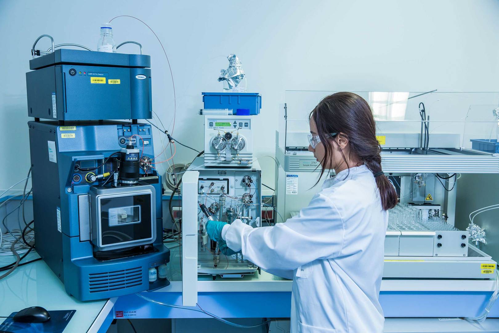 Female scientist working to replace a column with opened HPLC apparatus