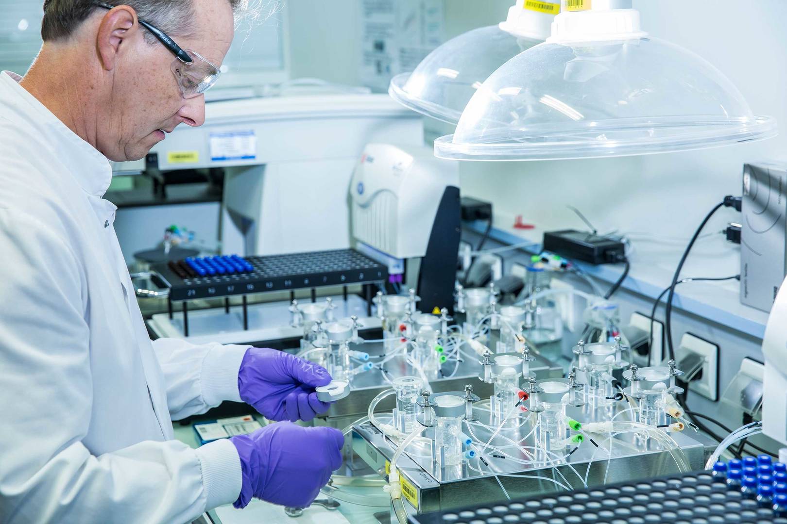 A technician wearing a labcoat is preparing an IVRT equipment