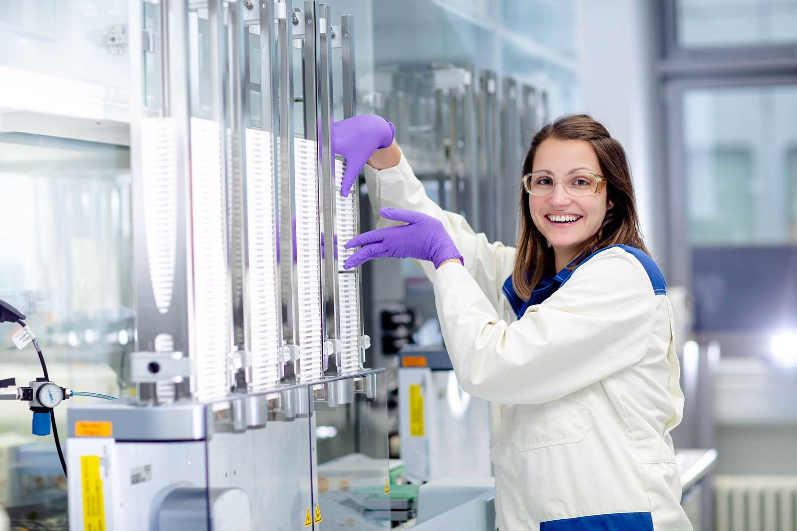 Screening expert processing a stack of assay plates 