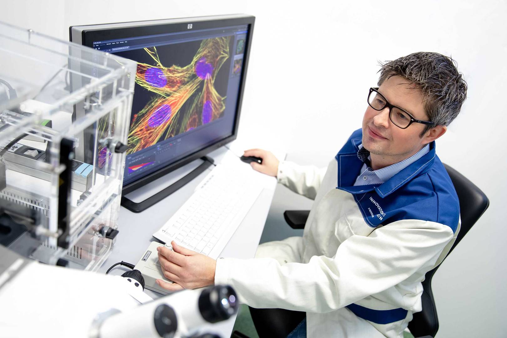 Scientist using a computer for immunofluorescence microscopy in a lab