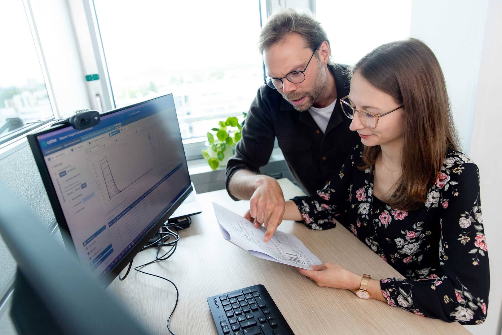 lab technician and scientist analyzing SPR data and discuss next experiments. 