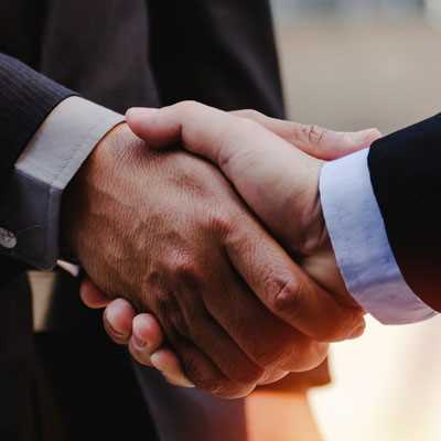 Close up of business man in suit shaking hands