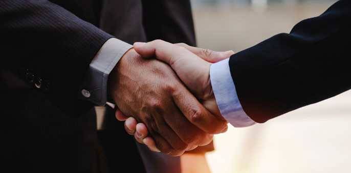 Close up of business man in suit shaking hands