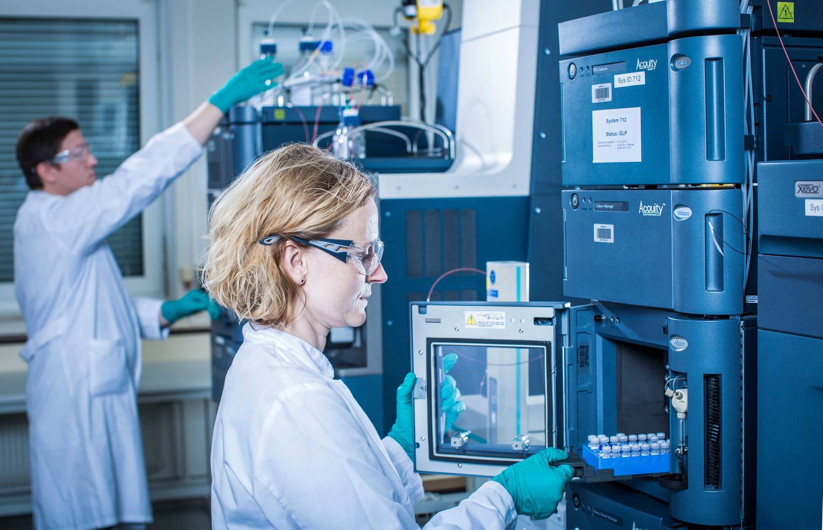A scientist operates an HPLC machine, analyzing samples in a laboratory setting with precision and focus.