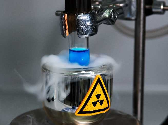 Lab vial with glowing liquid submerged in liquid nitrogen, featuring a prominent radioactivity symbol on its surface.