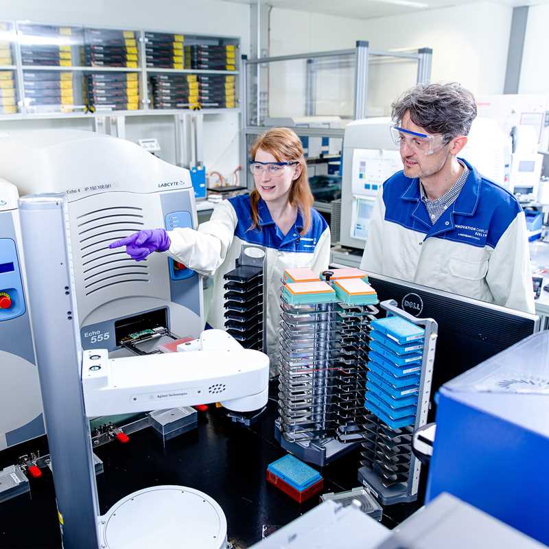 Young scientists explains an automated screening system to another person. 