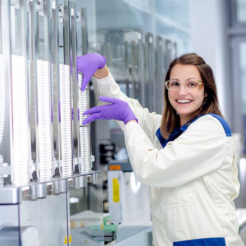 Screening expert processing a stack of assay plates